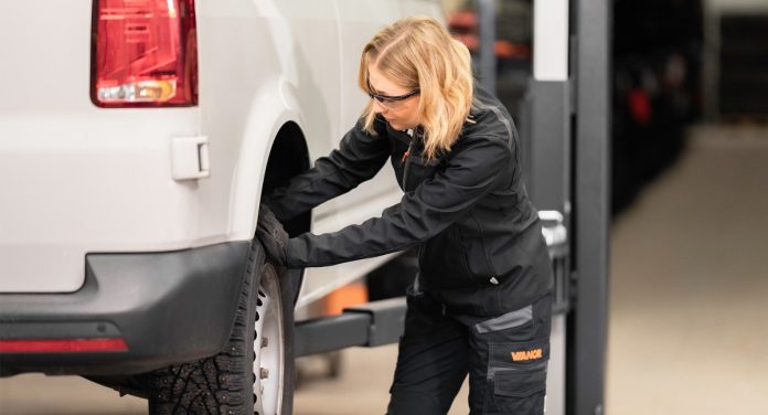 Auton huolto nainen ja takapyora Kuva Vianor